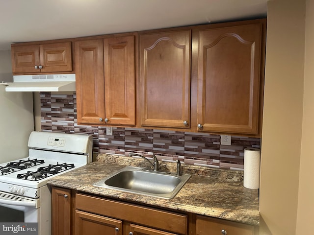 4415 Elizabeth St, Philadelphia, PA 19124 - kitchen featuring white gas stove, under cabinet range hood, a sink, decorative backsplash, and brown cabinets