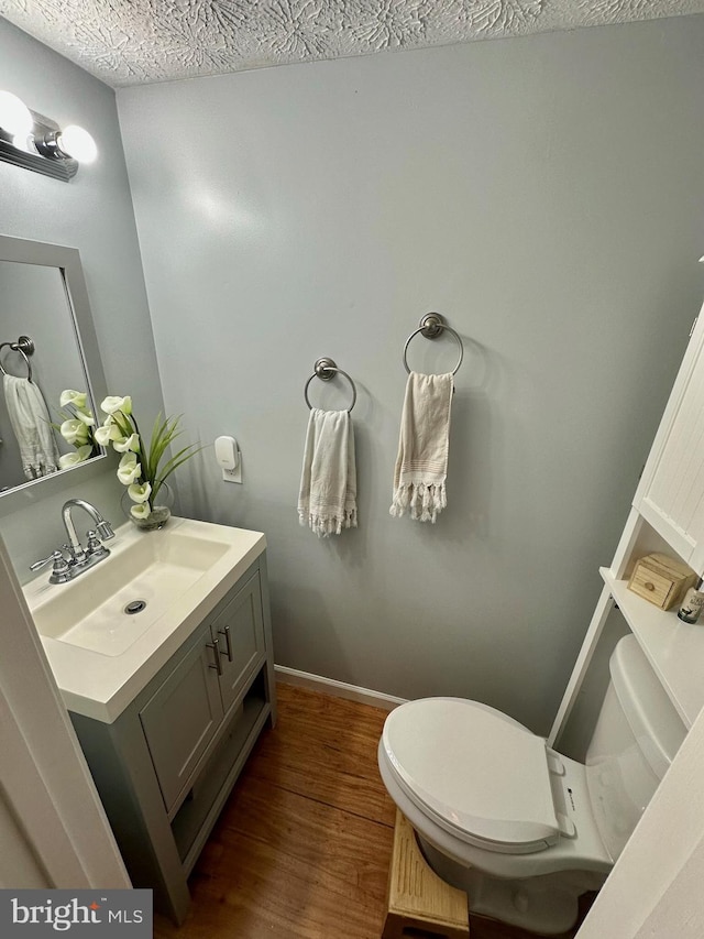 18628 Winding Creek Pl, Germantown, MD 20874 - bathroom featuring toilet, wood finished floors, vanity, and a textured ceiling