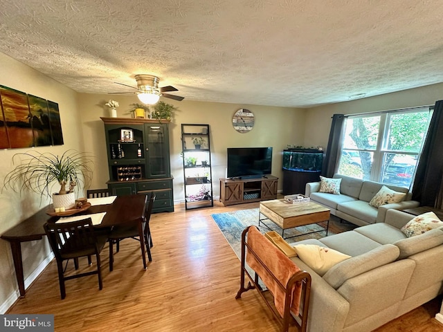 18628 Winding Creek Pl, Germantown, MD 20874 - living area with a textured ceiling, light wood finished floors, a ceiling fan, and baseboards