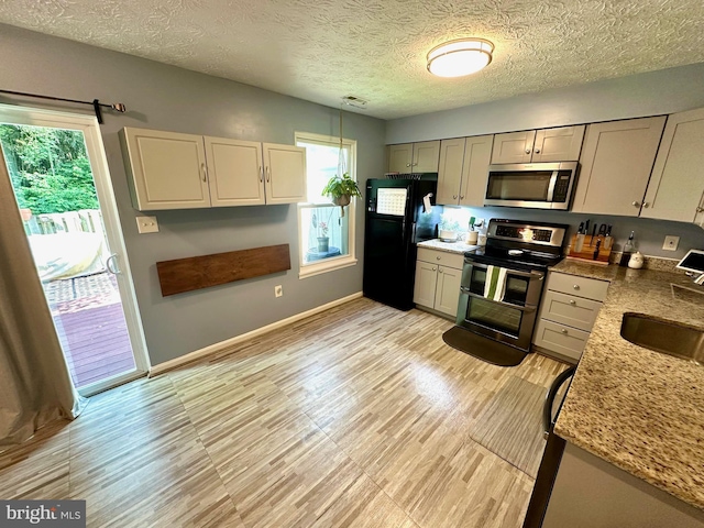 18628 Winding Creek Pl, Germantown, MD 20874 - kitchen featuring appliances with stainless steel finishes, a sink, gray cabinetry, baseboards, and a textured ceiling