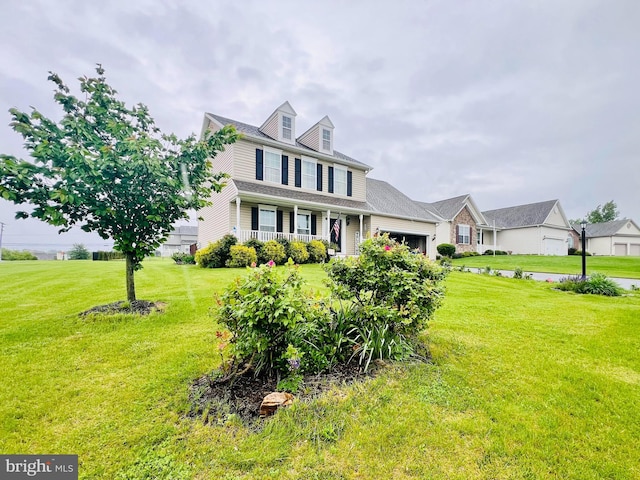 view of front of property featuring an attached garage, a front yard, and a porch