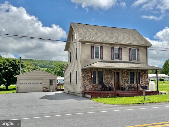 646 Nittany Valley Dr, Bellefonte, PA 16823 - view of front facade featuring a garage, an outdoor structure, stone siding, covered porch, and roof with shingles