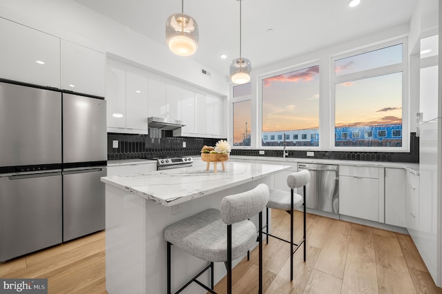 2201 E Somerset St Unit B3Lower, Philadelphia, PA 19134 - kitchen featuring appliances with stainless steel finishes, modern cabinets, white cabinetry, under cabinet range hood, and a kitchen breakfast bar
