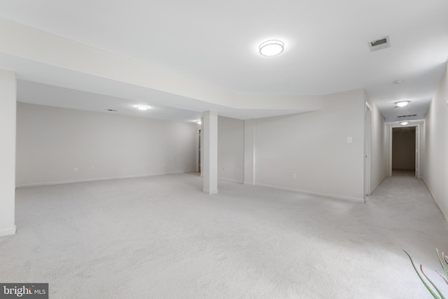 finished basement featuring light carpet and baseboards