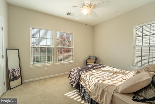 bedroom featuring multiple windows, carpet flooring, baseboards, and a ceiling fan