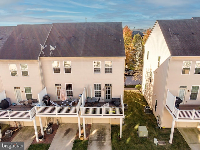 back of house featuring outdoor dining area, a deck, and central air condition unit