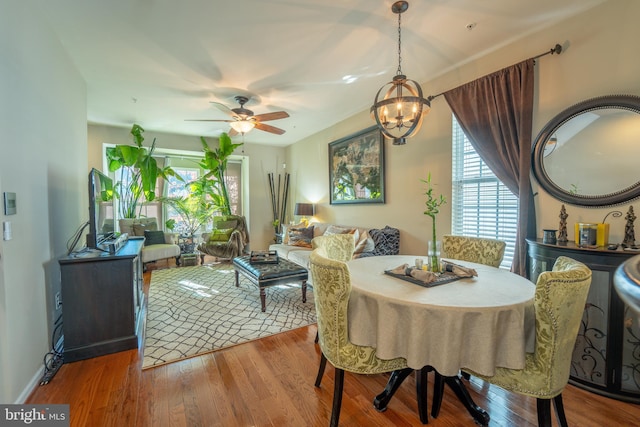 dining space featuring a chandelier, wood finished floors, and a ceiling fan