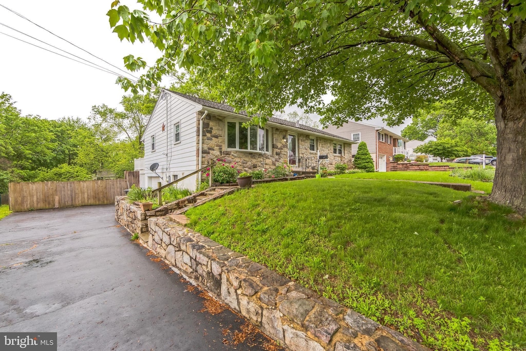 ranch-style house featuring stone siding