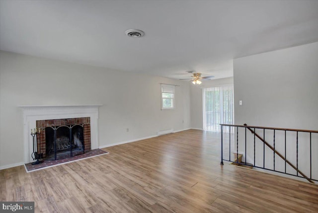 102 Andover Ct, Frederick, MD 21702 - unfurnished living room with wood finished floors, a brick fireplace, a ceiling fan, and baseboards