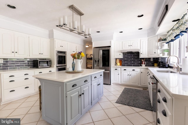 1765 Stone Dr, Huntingtown, MD 20639 - kitchen featuring appliances with stainless steel finishes, a sink, tasteful backsplash, light tile patterned floors, and ornamental molding