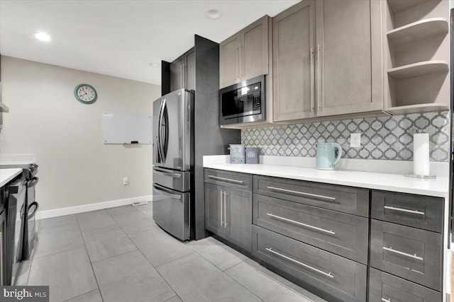 907 Sterling Ct, Herndon, VA 20170 - kitchen with stainless steel appliances, open shelves, backsplash, light countertops, and baseboards