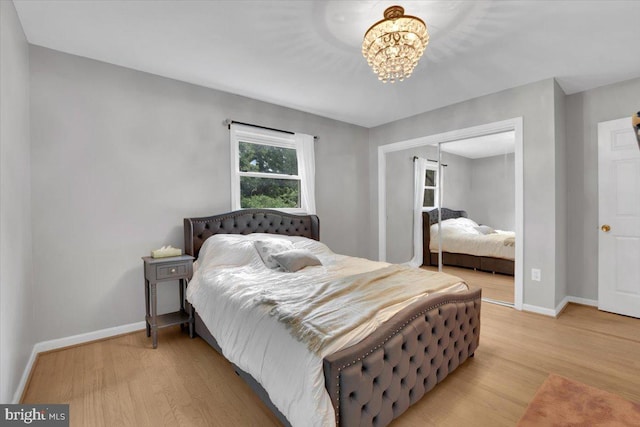 907 Sterling Ct, Herndon, VA 20170 - bedroom with baseboards, light wood finished floors, a closet, and a chandelier