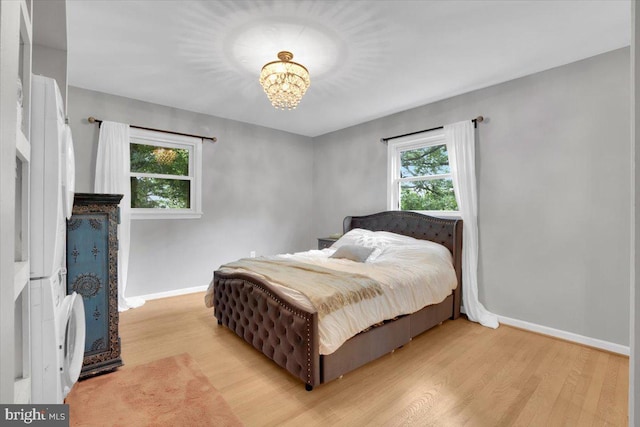 907 Sterling Ct, Herndon, VA 20170 - bedroom with baseboards, a chandelier, and light wood-style flooring