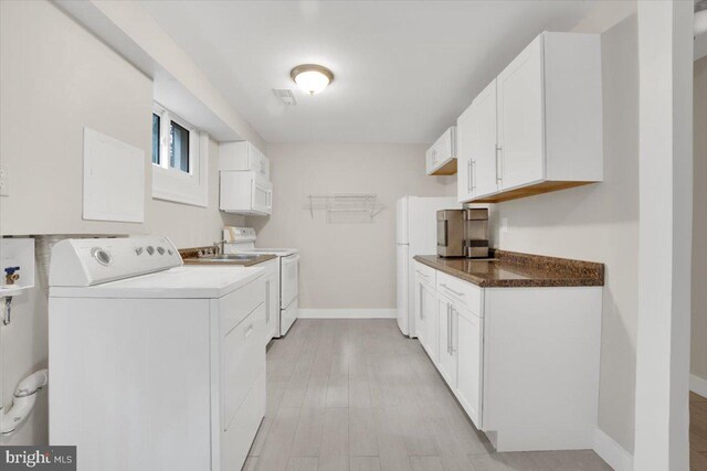 907 Sterling Ct, Herndon, VA 20170 - washroom featuring separate washer and dryer, baseboards, and light wood-style flooring