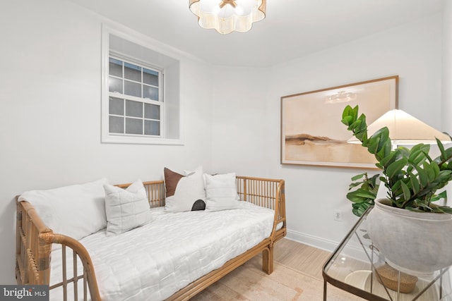 living area with wood finished floors, baseboards, and a chandelier