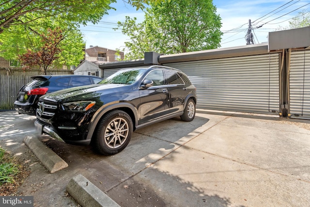 view of vehicle parking featuring fence