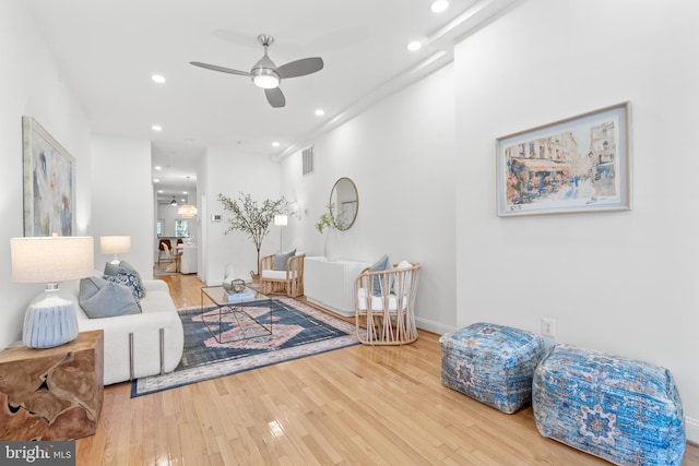 living area with a ceiling fan, wood finished floors, recessed lighting, and baseboards