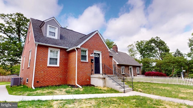 724 Overbrook Rd, Baltimore, MD 21212 - view of front facade with brick siding, central AC unit, a chimney, and roof with shingles