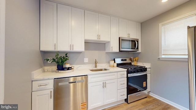 724 Overbrook Rd, Baltimore, MD 21212 - kitchen with stainless steel appliances, a sink, light wood-type flooring, white cabinets, and recessed lighting