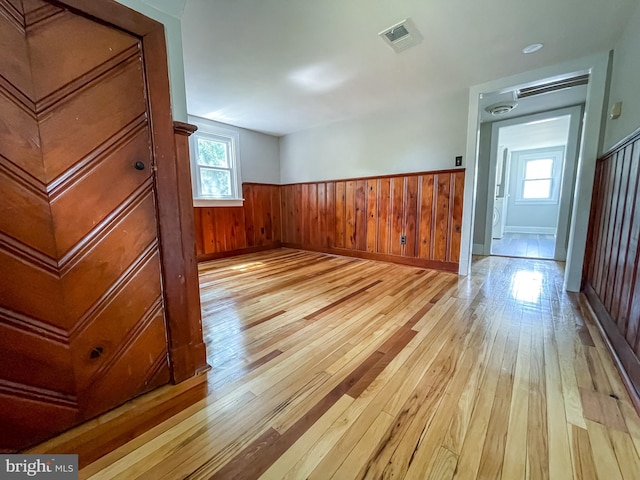 1021 Park Ave, Annapolis, MD 21403 - spare room featuring light wood-style flooring, a wainscoted wall, healthy amount of natural light, and wooden walls