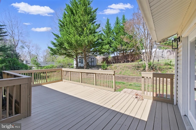 deck featuring a storage shed, an outbuilding, and a fenced backyard