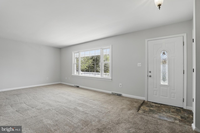 carpeted foyer featuring baseboards