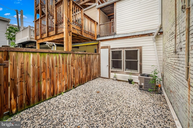 view of side of home with central AC and fence