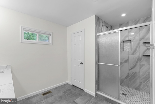 bathroom featuring a shower stall and baseboards