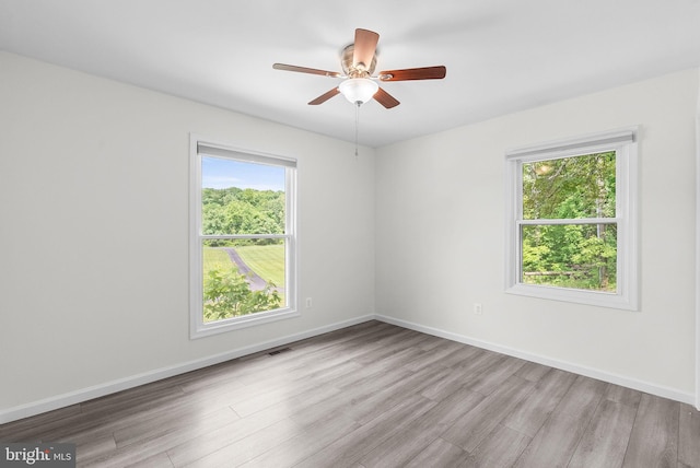 unfurnished room featuring wood finished floors, ceiling fan, and baseboards