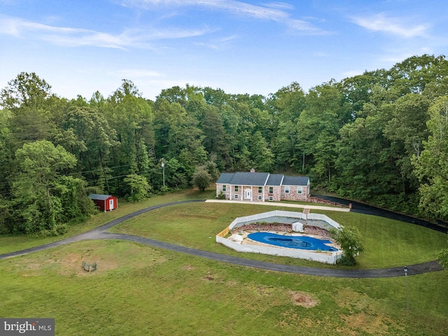 view of subject property featuring a heavily wooded area and a pool area