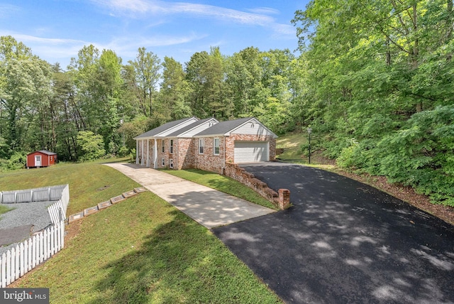view of front of house featuring asphalt driveway, an attached garage, brick siding, and a forest view
