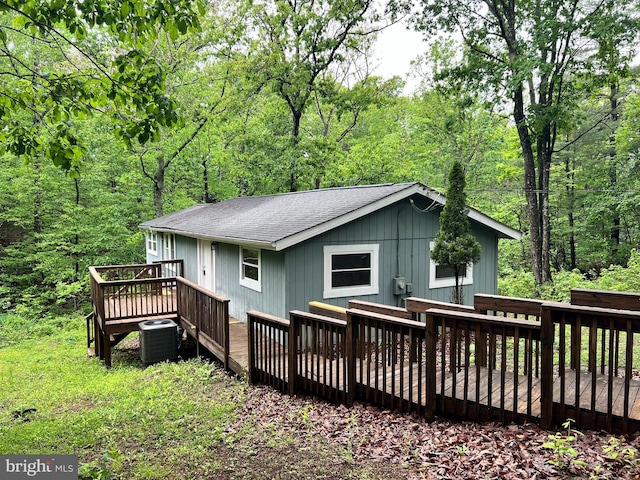 129 Raccoon Ln, Gerrardstown, WV 25420 - rear view of house featuring a shingled roof, a deck, central AC unit, and a view of trees