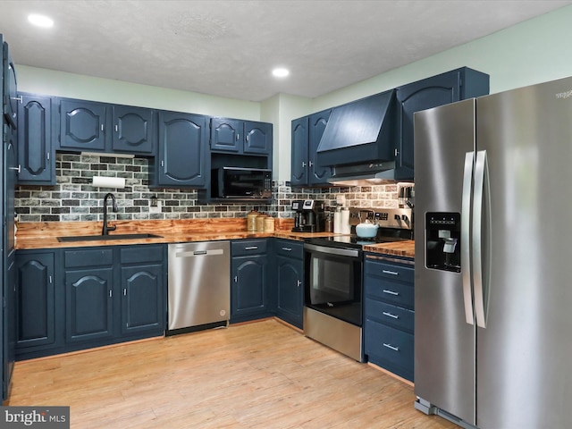 55 Powell Ln, Front Royal, VA 22630 - kitchen featuring stainless steel appliances, a sink, wood counters, wall chimney range hood, and decorative backsplash