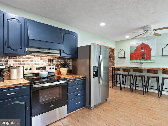 55 Powell Ln, Front Royal, VA 22630 - kitchen featuring appliances with stainless steel finishes, blue cabinets, wooden counters, under cabinet range hood, and ceiling fan
