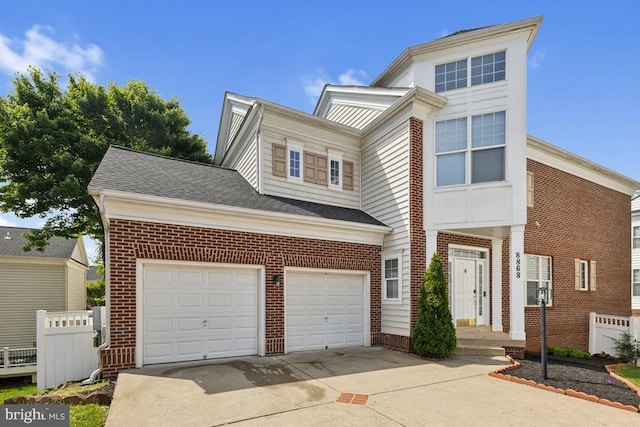 view of front of house featuring concrete driveway, brick siding, fence, a garage, and roof with shingles