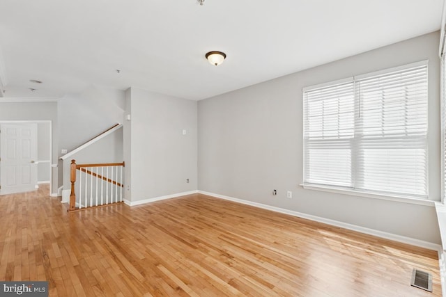 spare room with light wood-style floors, plenty of natural light, and baseboards