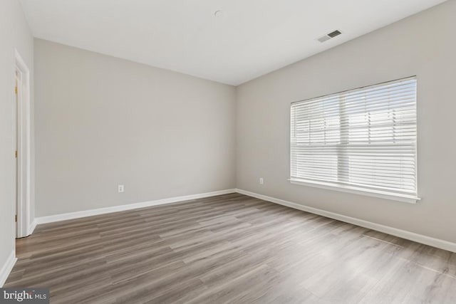unfurnished room with baseboards and wood finished floors