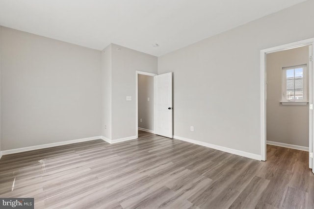 unfurnished room with wood finished floors and baseboards