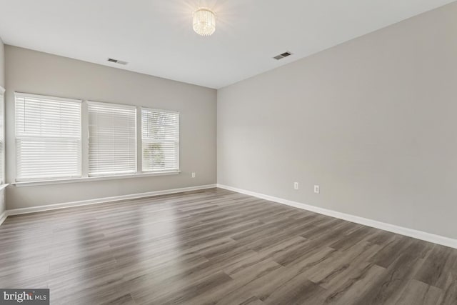 empty room with baseboards and wood finished floors