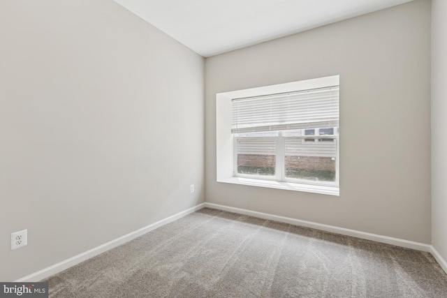unfurnished room featuring carpet and baseboards