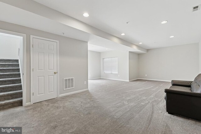 carpeted living area with stairway, baseboards, and recessed lighting