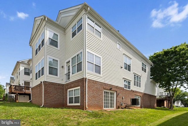 rear view of property featuring brick siding and a lawn