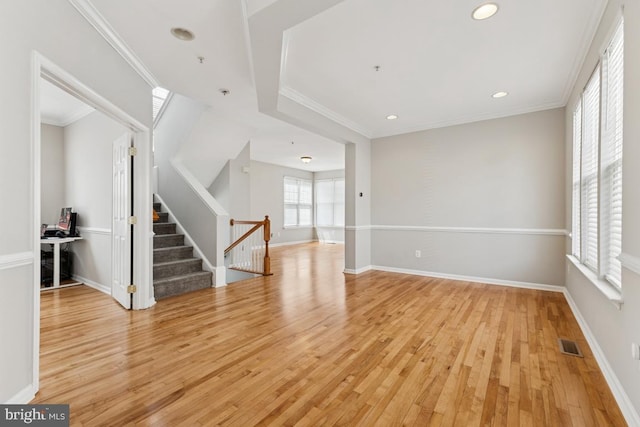 empty room with light wood-type flooring, stairway, recessed lighting, baseboards, and crown molding