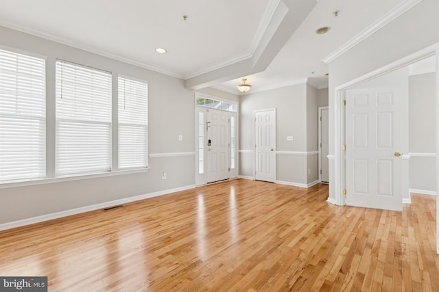 entryway with light wood-style floors, crown molding, and baseboards