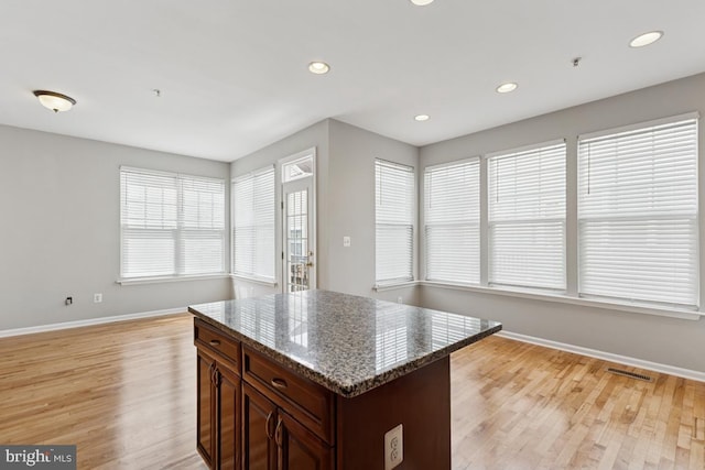 kitchen with baseboards, light wood-style flooring, healthy amount of natural light, and recessed lighting