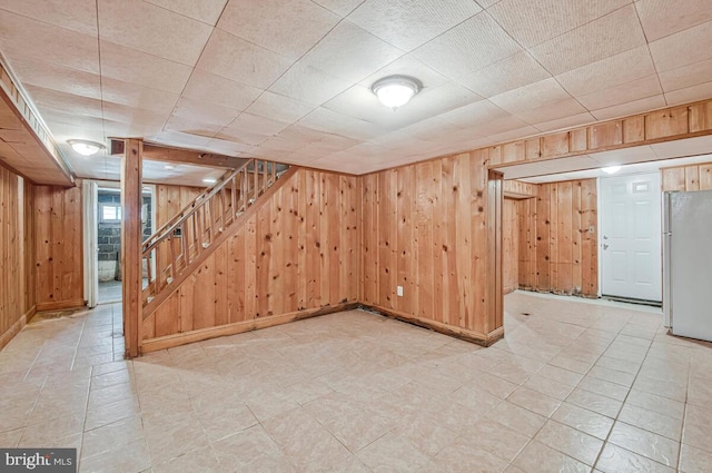 9425 Washington Blvd, Lanham, MD 20706 - basement with freestanding refrigerator, wood walls, stairway, and baseboards