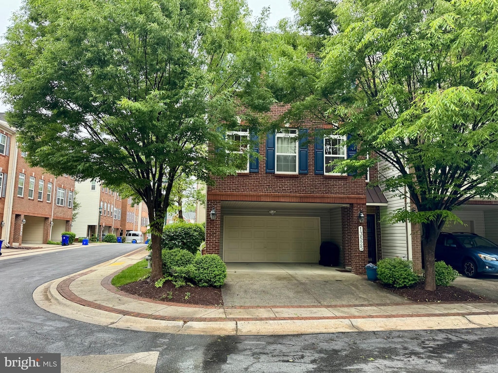 view of front of property with a garage, concrete driveway, and brick siding