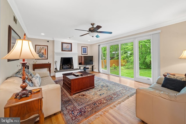 205 Hitching Post Dr, Wilmington, DE 19803 - living room with light wood-type flooring, a ceiling fan, ornamental molding, a fireplace with raised hearth, and recessed lighting