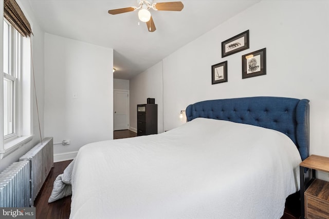3182 Miller St, Philadelphia, PA 19134 - bedroom with radiator heating unit, dark wood-style flooring, multiple windows, and baseboards