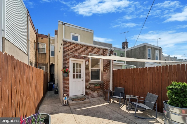 3182 Miller St, Philadelphia, PA 19134 - rear view of property featuring brick siding, a patio area, and a fenced backyard